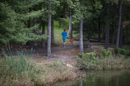 A man and his dog jogging along a lake