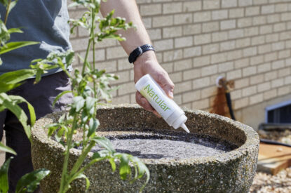 A Shaker Bottle Of Natular DT Being Applied To A Bird Bath For Residential Backyard Control